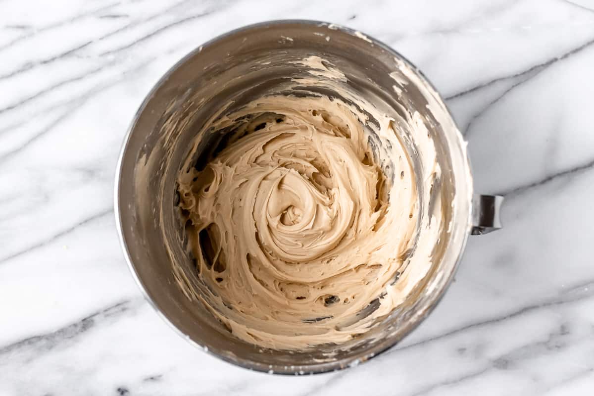 Caramel buttercream frosting in a silver bowl.