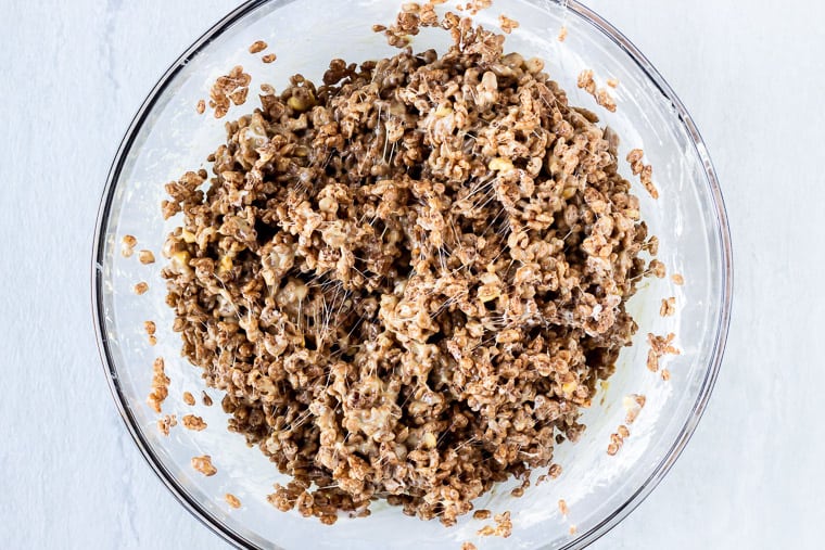 Cocoa Rice Krispies mixture in a glass bowl over a white background