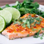 Sweet Chili Salmon on a White Plate with Limes and Cilantro