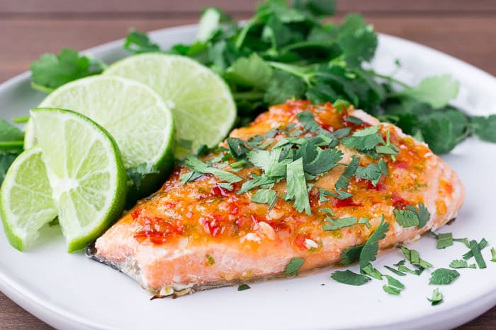 Sweet Chili Salmon on a White Plate with Limes and Cilantro