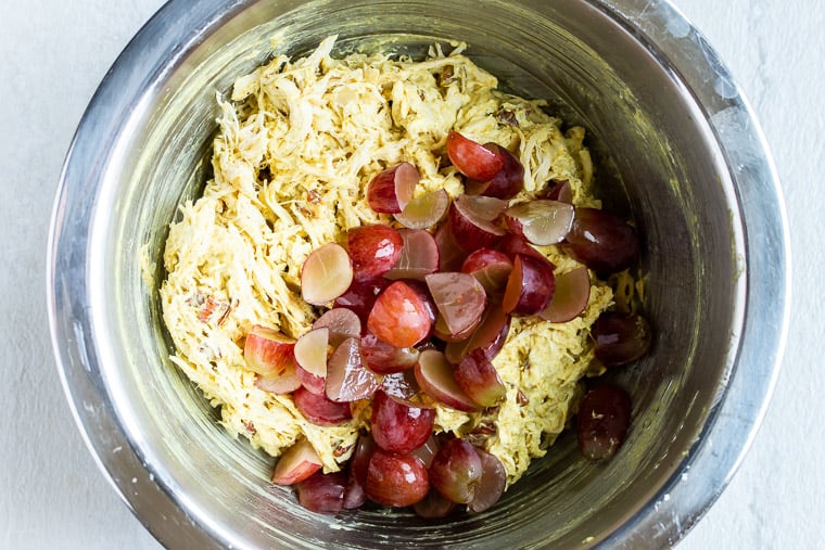 Curry Chicken Salad with grapes on top in a silver bowl