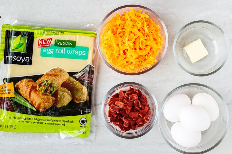 Ingredients needed to make breakfast egg rolls laid out on a white background