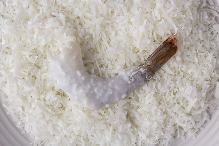Shrimp laying on a plate of coconut shreds
