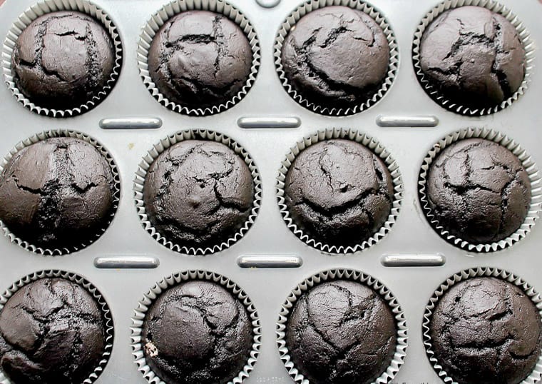 Baked dark chocolate cupcakes in a cupcake pan
