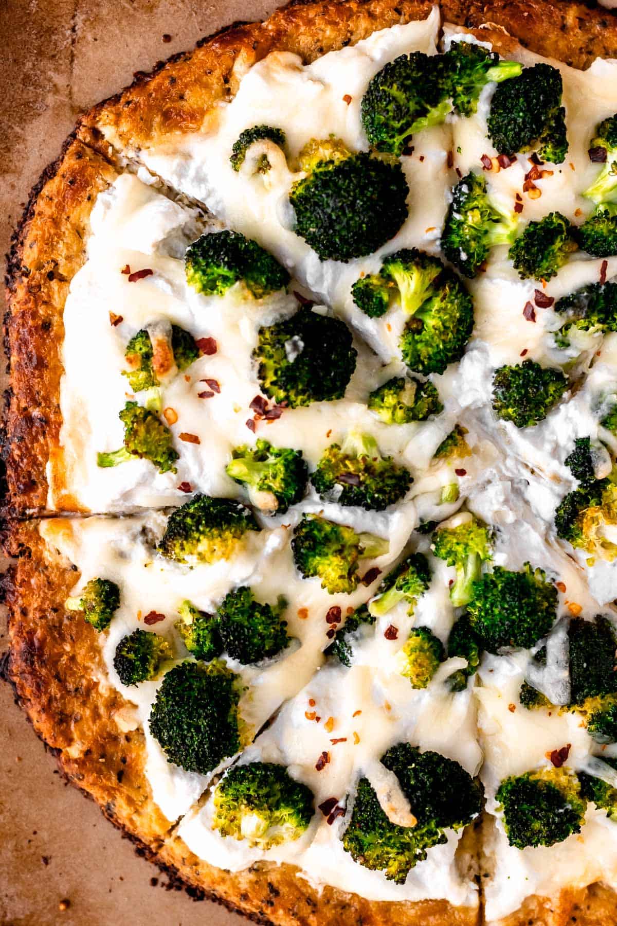 Close up of a ricotta pizza with broccoli and roasted garlic.