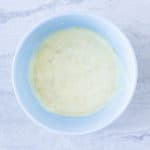 Roasted Garlic Lemon Aioli in a light blue bowl over a white background