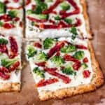 close up of a pizza bianca on a cauliflower pizza crust with one slice pulled away some