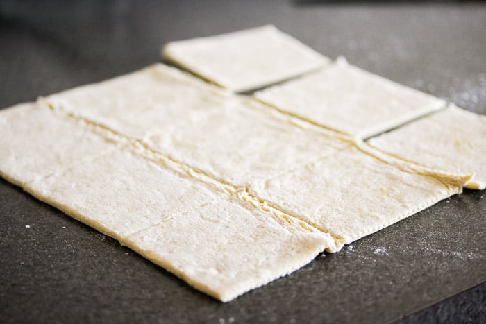 Puff Pastry Cut Into 9 Squares on a gray counter