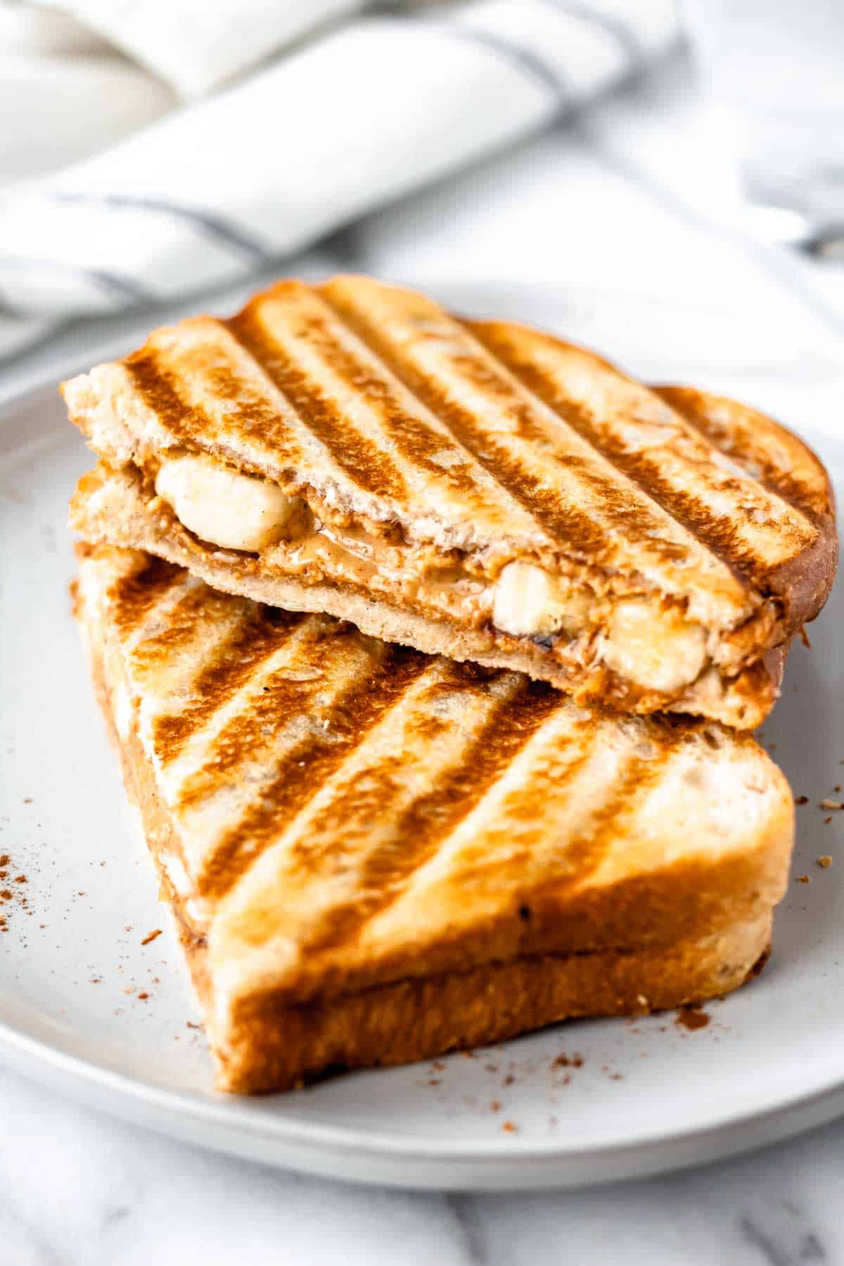 A fried peanut butter and banana sandwich on a white plate.