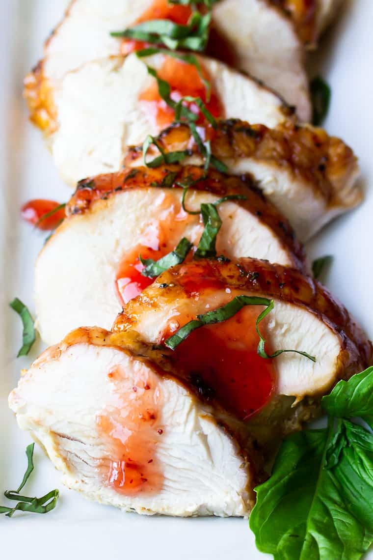 Strawberry basil turkey slices on a white serving tray with fresh basil leaves
