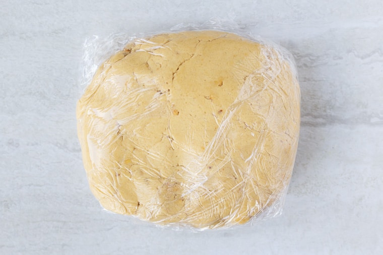 Peanut Butter Cookie dough wrapped in plastic on a white background