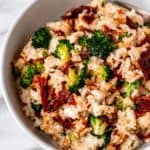Close up of cream cheese rice with broccoli and sun-dried tomatoes.