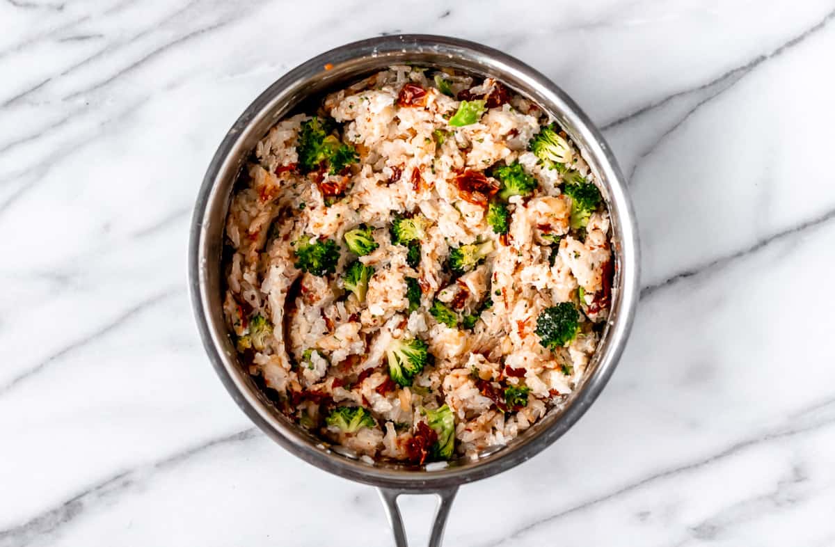 Cream cheese rice with broccoli and sun-dried tomatoes in a pot.