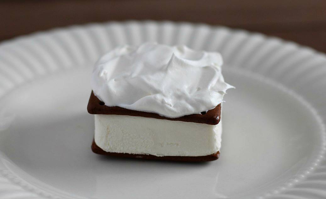 an Ice Cream Sandwich Topped with Whipped Topping on a white plate