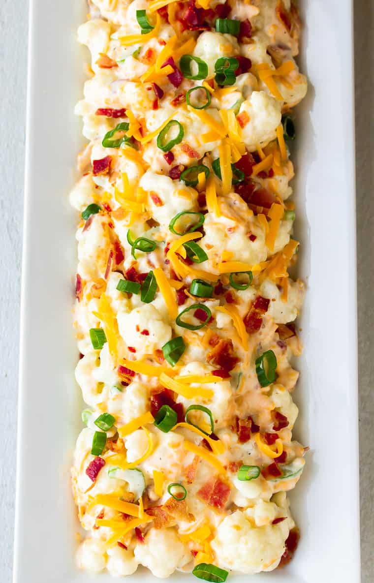 Overhead view of Bacon Ranch Cauliflower Salad on a long white rectangular serving tray