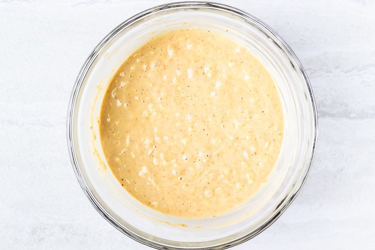 Peanut Butter Muffin batter in a glass bowl over a white background