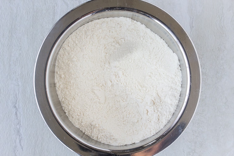 dry flour mixture in a silver bowl over a white backdrop
