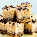 Close up of S'more Rice Krispie Treats stacked on a light yellow plate and a white background