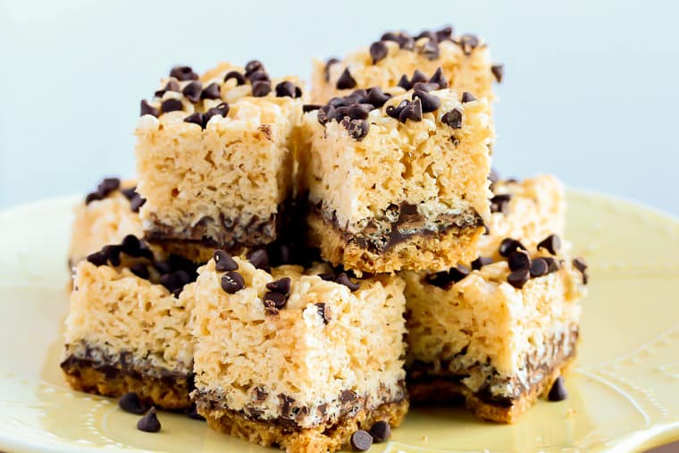 Close up of S'mores Rice Krispie Treats stacked on a light yellow plate and a white background