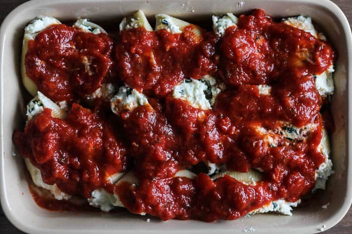 Stuffed Shells Topped with Pasta Sauce in a rectangular casserole dish