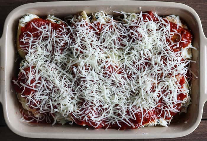 Stuffed Shells Topped with Tomato Sauce and Cheese in a casserole dish before being baked