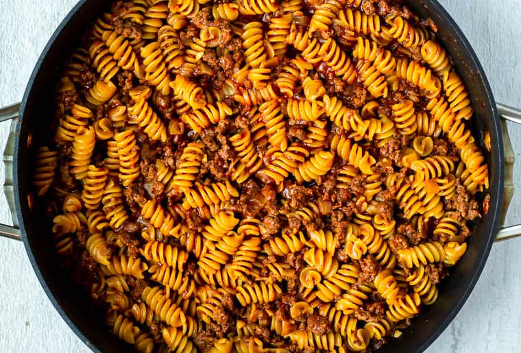 Pasta and ground beef in a black pan