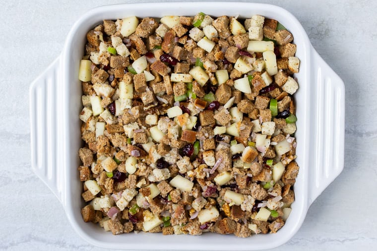 Stuffing in a white square casserole dish over a white background