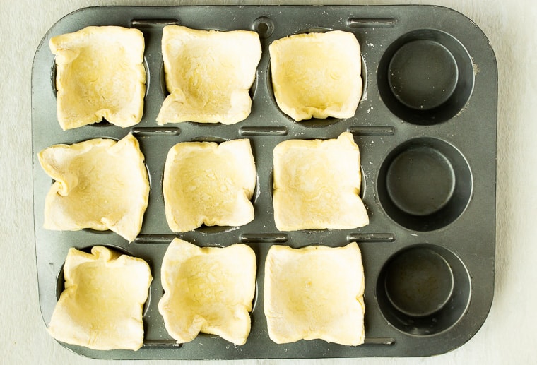 Puff pastry squares in 9 wells of a cupcake pan