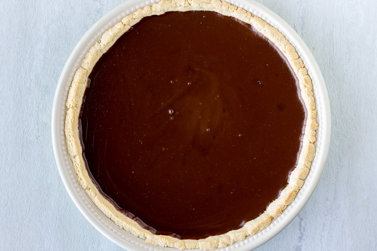 Chocolate cream pie filling in a pie crust over a white background