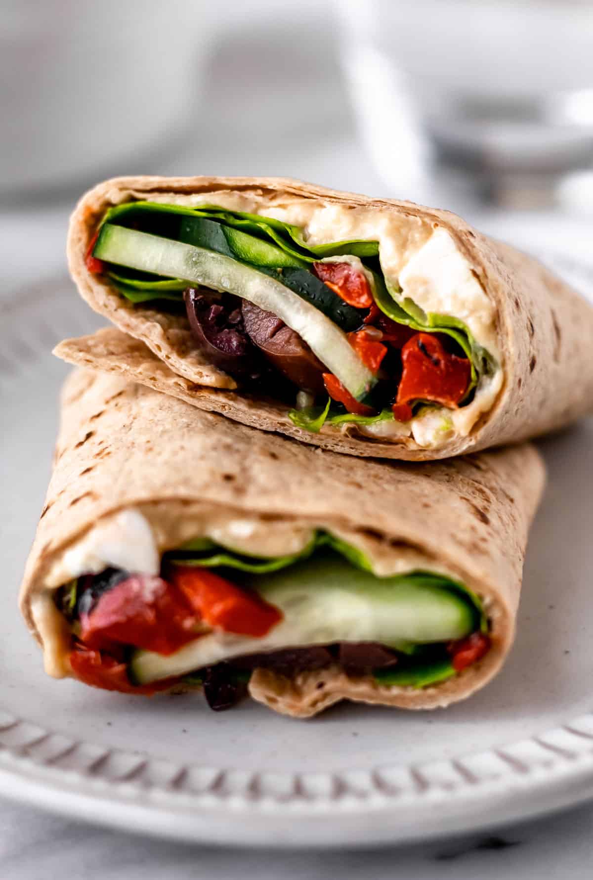 Close up of a Greek Veggie Wrap cut in half and stacked on top of each other.