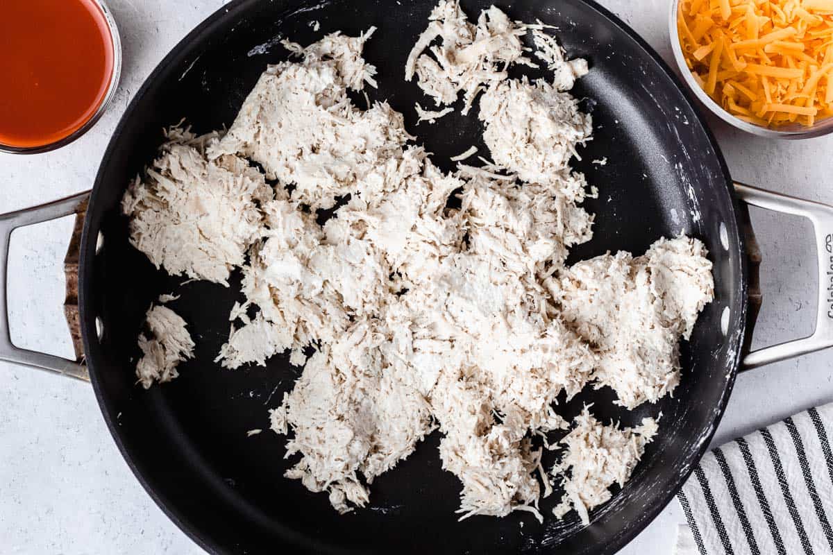 Cream cheese and chicken blended together in a black skillet