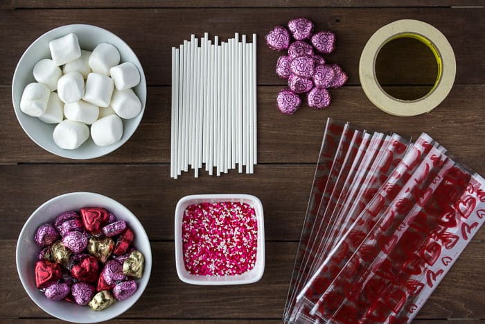 All of the Supplies Need to Make the Candy Kabobs layed out on a wood background