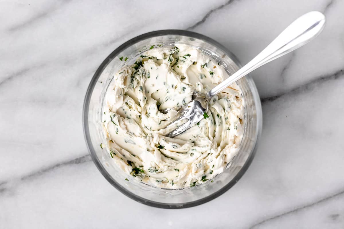 Herbed cream cheese in a bowl with a fork.