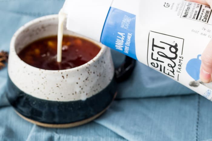 Pouring Left Field Farms Coffee Creamers into a Mug with Chai Tea
