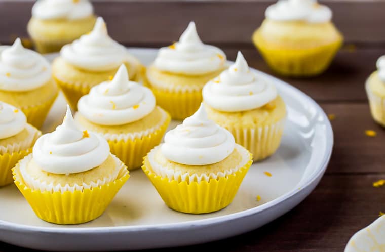 Mini Lemon Cupcakes on a white tray over a wood backdrop