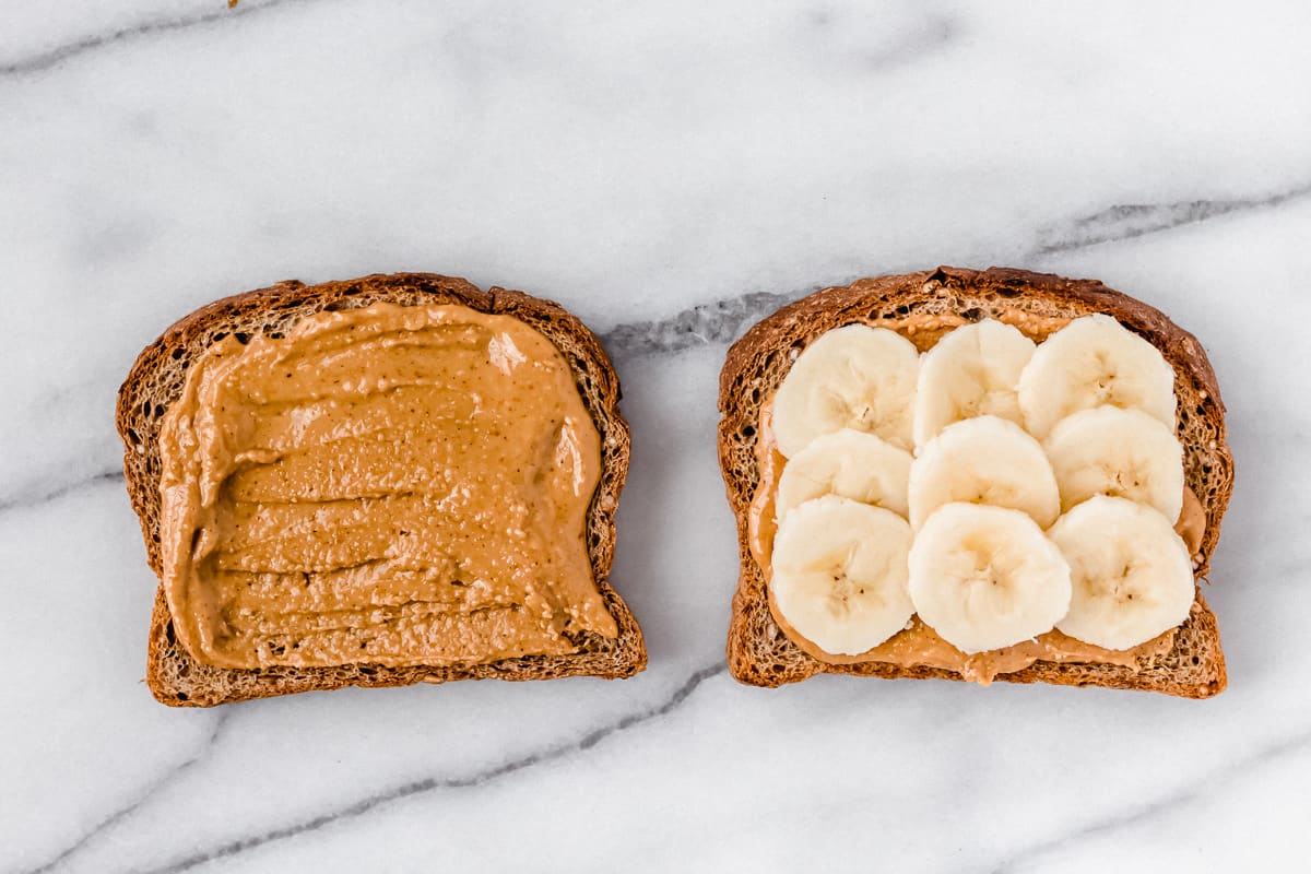 One slice of toast with peanut butter and one with peanut butter and banana slices