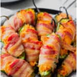 Buffalo chicken jalapeno poppers on a black plate with text overlay