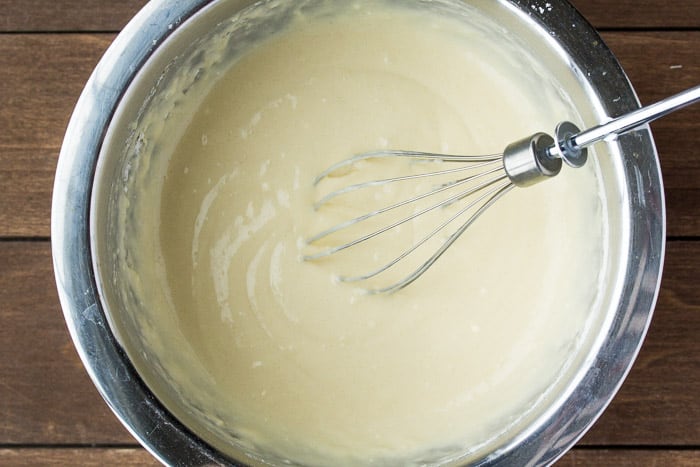 Pancake Batter in a Bowl with a whisk on a wood background