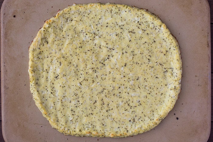 Homemade Cauliflower Pizza Crust on a Pizza Stone prior to baking