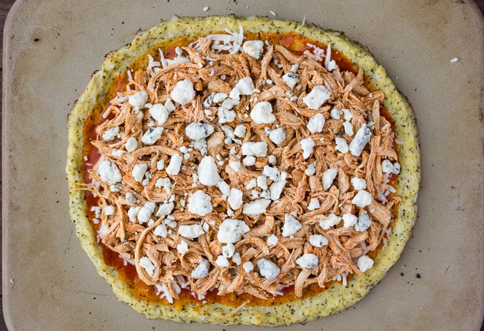 Buffalo Chicken Pizza on a cauliflower crust prior to baking on a pizza stone