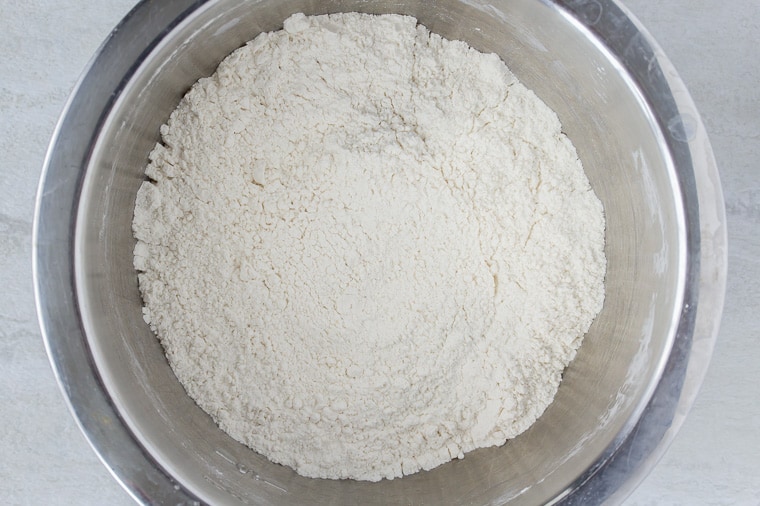 Dry Ingredients for Scones in a Silver Mixing Bowl on a white backdrop