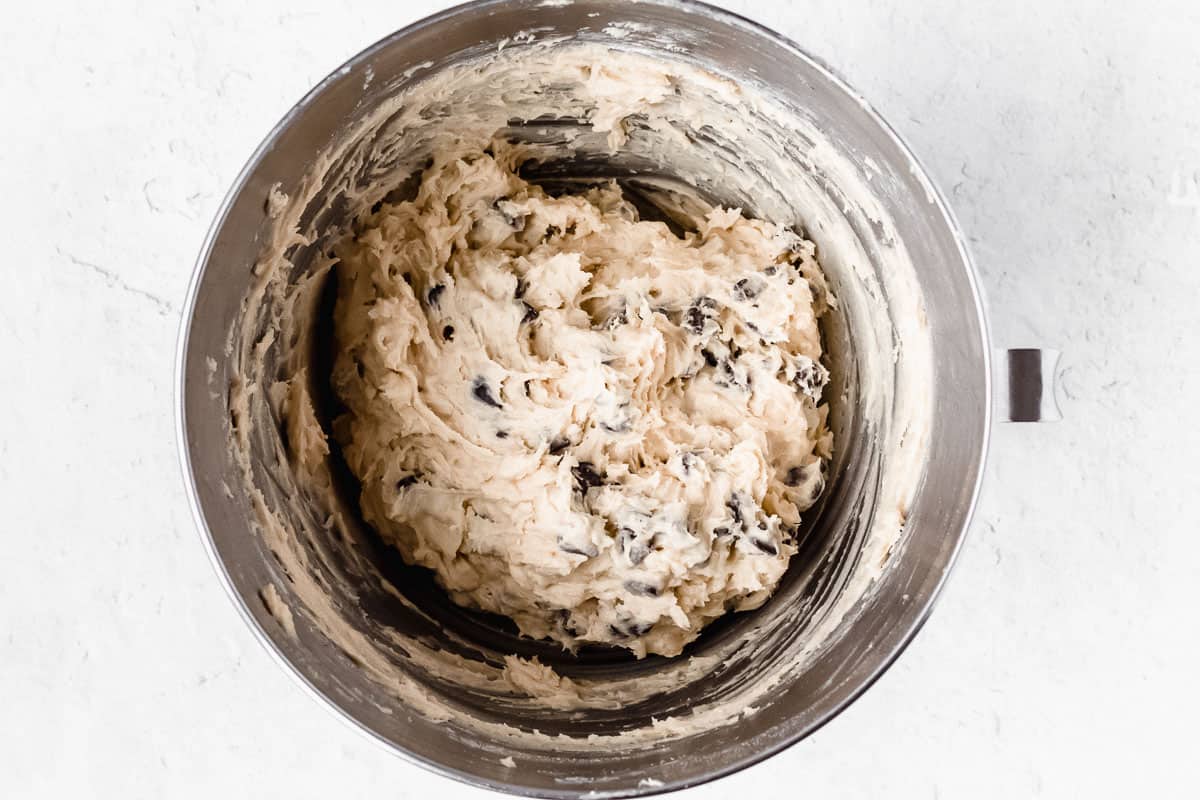 Chocolate chip cookie dough in a silver mixing bowl
