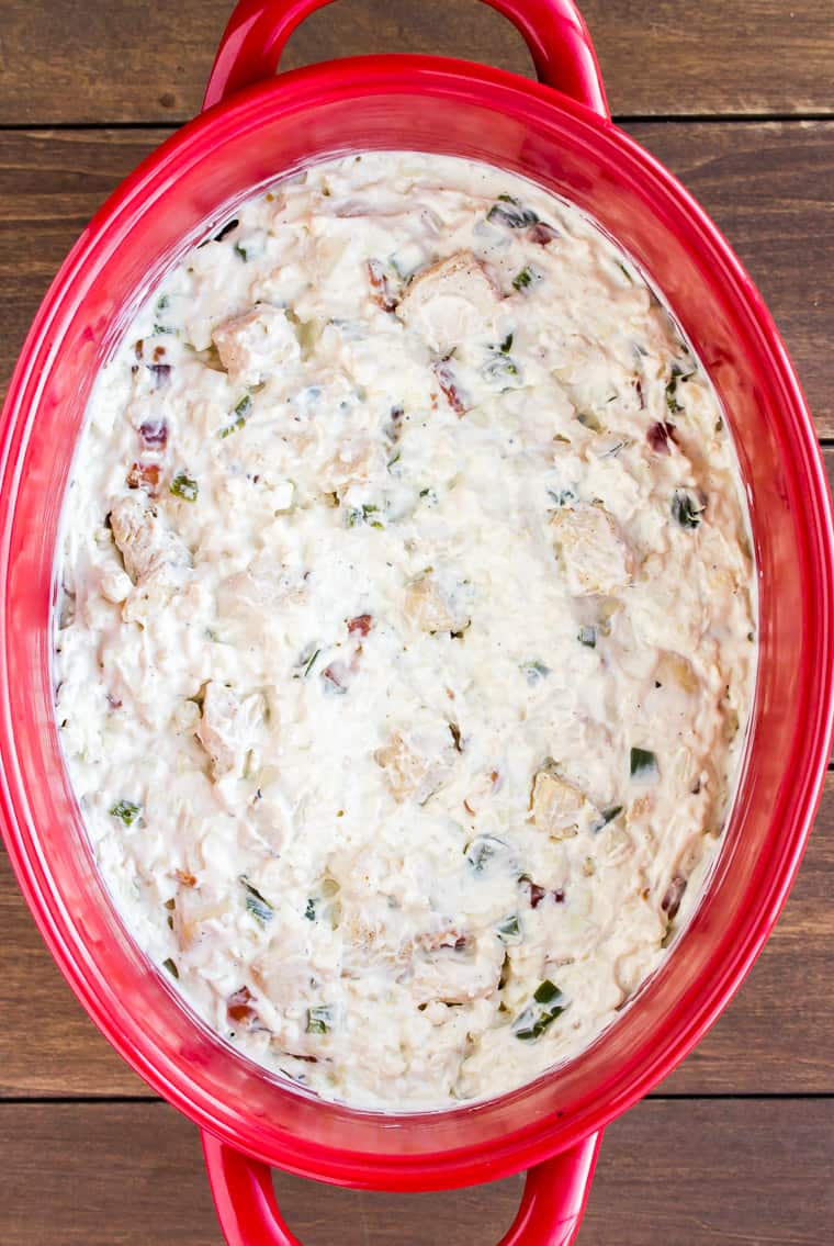 Overhead View of an Unbaked Jalapeno Popper Casserole in a Red Casserole Dish on a Wood Background