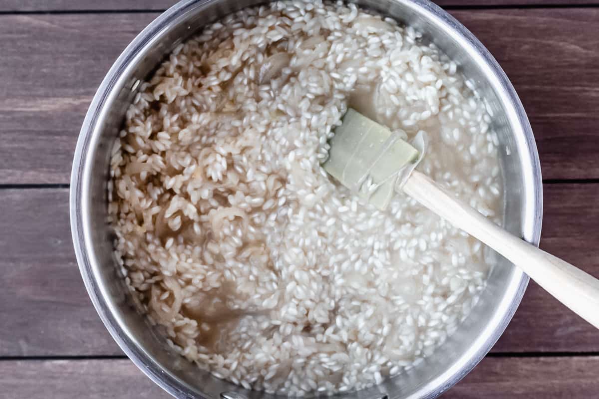 Risotto rice in a silver pot with a spatula