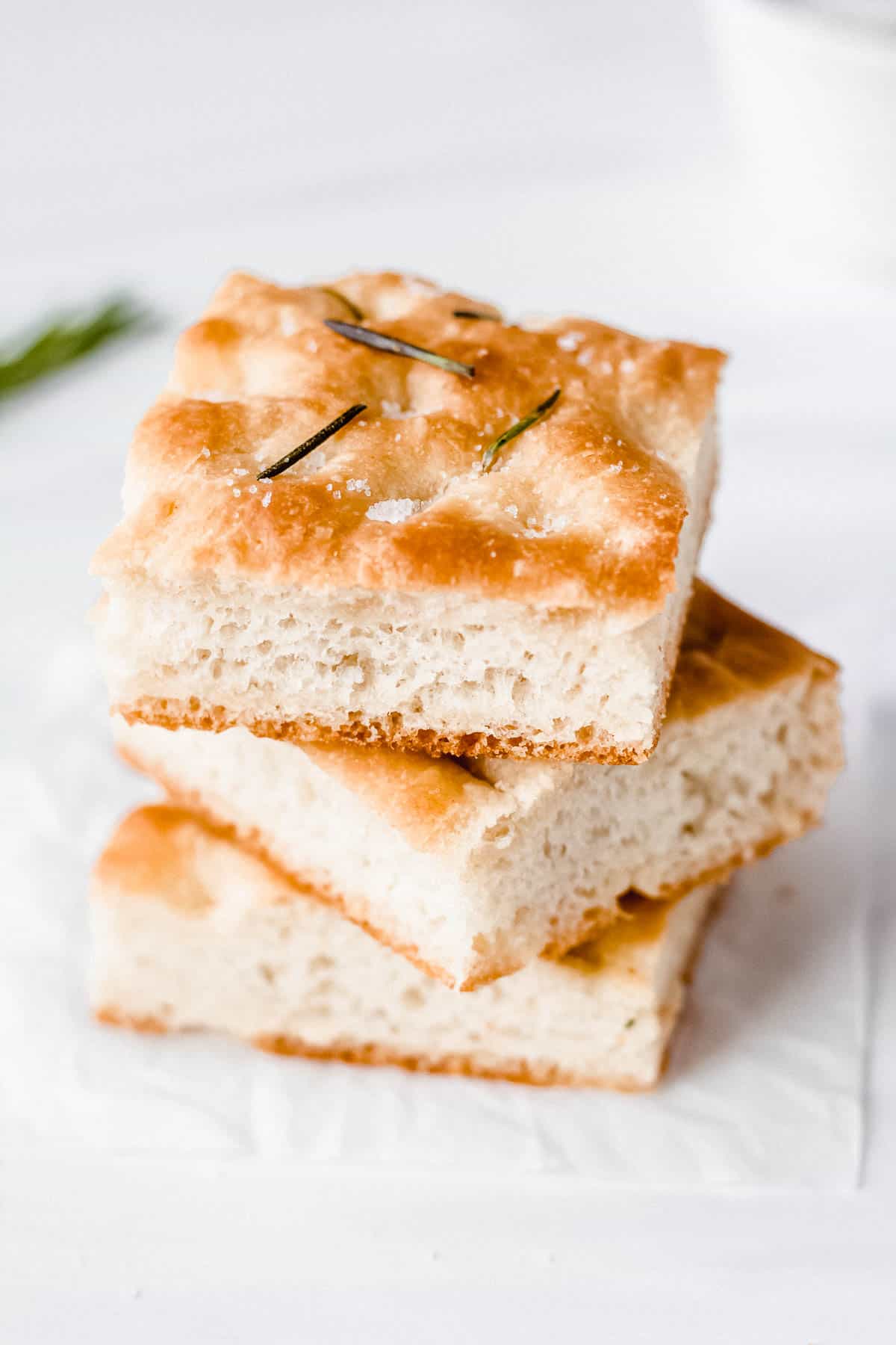 3 pieces of focaccia stacked on top of each other on a white background