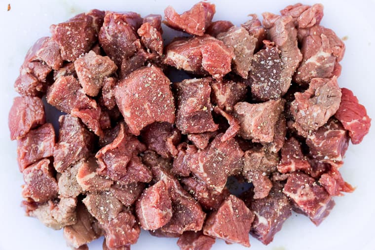 Stew Meat on a white Cutting Board