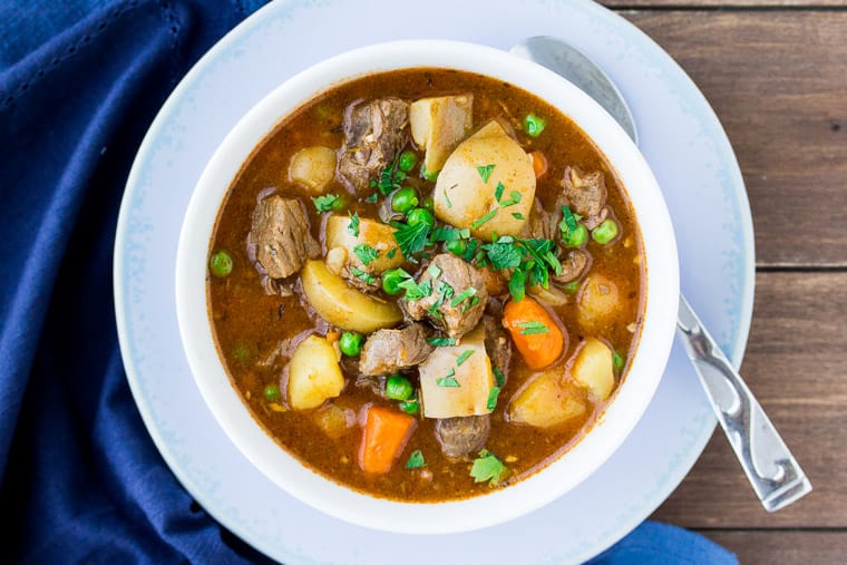 Instant Pot Beef Stew from Overhead in a white Bowl with a Blue Napkin