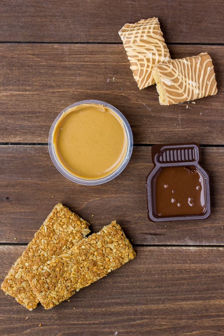Different Granola Bars with Cups of Peanut Butter and Chocolate Hazelnut Dip