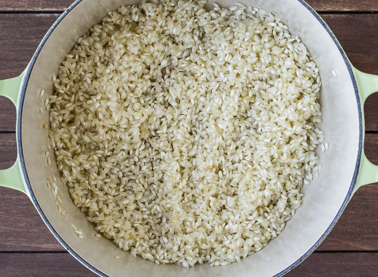 Rice Cooking in a Dutch Oven over a wood background