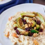 Roasted Butternut Squash Risotto with Brussels Sprouts, Cranberries, and Walnut on a Blue Plate with a Blue Napkin